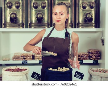Female is selling Macadamia and on the plate is written in Catalan in the food store. - Shutterstock ID 760202461