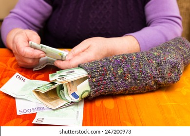 Female Senior Adult With A Sock Full Of Money