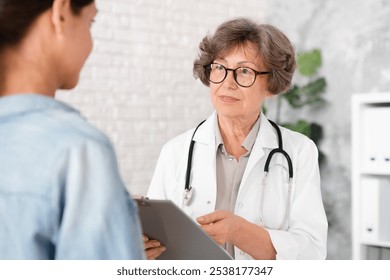 Female senior doctor explaining telling diagnosis to woman patient, showing test results, diagnosis, prescribing medications pills drugs at hospital - Powered by Shutterstock