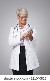 Female Senior Doctor With Smart Phone 