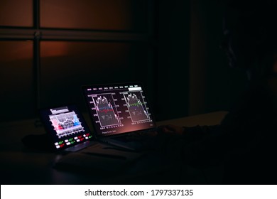 Female Share Trader At Desk With Stock Price Data Displayed On Laptop And Digital Tablet