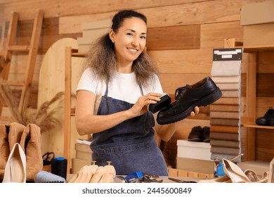 Female shoemaker polishing leather boot in workshop - Powered by Shutterstock