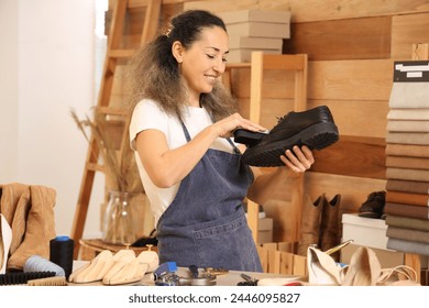 Female shoemaker polishing leather boot in workshop - Powered by Shutterstock