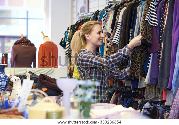 Female Shopper\
In Thrift Store Looking At\
Clothes