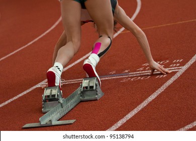 Female short distance runner  is in start position - Powered by Shutterstock