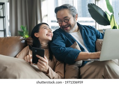 Female showing smartphone to husband in living room at home