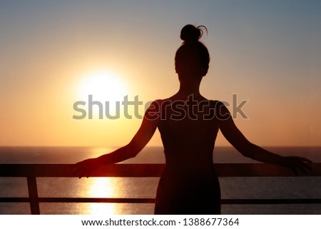 Female Silhouette at the Balcony Admiring Sunrise. Woman looking forward into the horizon hoping for future accomplishes 