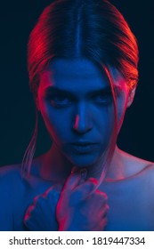 Female Silhouette Portrait. Human Helplessness. Scared Woman Bare Shoulder In Neon Light Glow Looking At Camera Isolated On Black. Toxic Relationship. Feminine Power. Abuse Violence