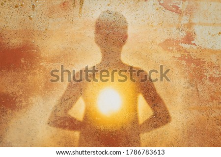 Female silhouette radiating light from within a spiritual heart opening.