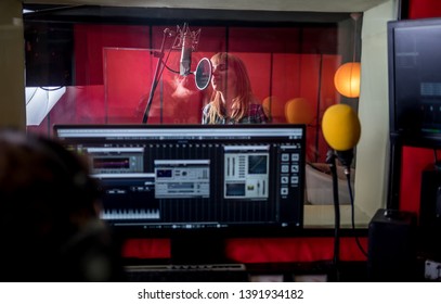 Female singer during vocal recording at music studio - Powered by Shutterstock