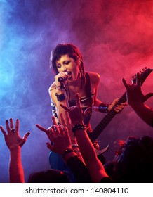 Female Singer And Guitarist Playing Guitar At A Rock Concert