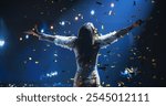 Female Singer Performing in a Striking Silver Costume. Spectacular Concert with a Talented Pop Star. Epic Cinematic Slow Motion Footage with Vibrant Confetti Falling on Artists on Stage