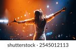 Female Singer Performing in a Striking Silver Costume. Spectacular Concert with a Talented Pop Star. Epic Cinematic Slow Motion Footage with Vibrant Confetti Falling on Artists on Stage