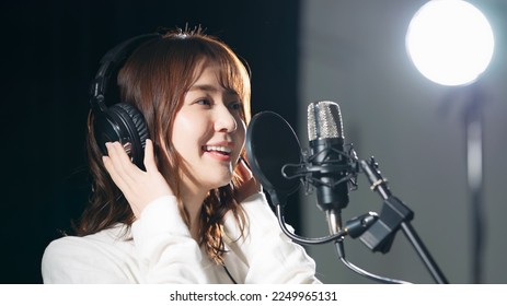 Female singer recording in studio.