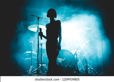 Female Singer Silhouette In Front Of A Smoky Stage