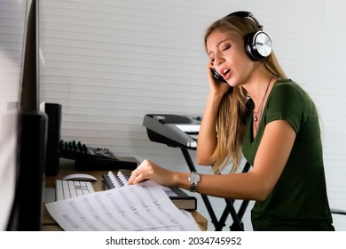 Female singer wearing headphone working in voice recording studio. Shoot with high iso 6400 with noise in image file. - Powered by Shutterstock