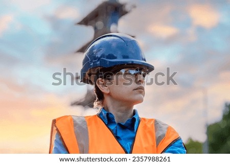 Female site engineer surveyor working with theodolite total station EDM equipment on a building construction site outdoors