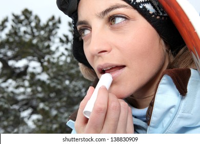 Female Skier Applying Lip Balm