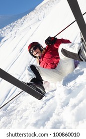 Female Skier Sitting In Snow With After Fall