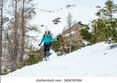 Female Skiier Enjoying Back Country Skiing In The Mountains.