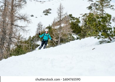 Female Skiier Enjoying Back Country Skiing In The Mountains.