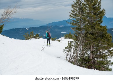 Female Skiier Enjoying Back Country Skiing In The Mountains.