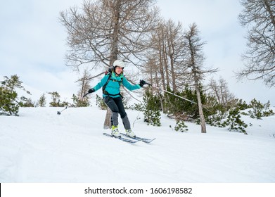 Female Skiier Enjoying Back Country Skiing In The Mountains.