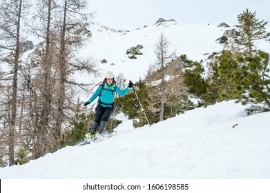 Female Skiier Enjoying Back Country Skiing In The Mountains.