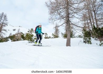 Female Skiier Enjoying Back Country Skiing In The Mountains.