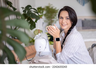 Female skilled dressmaker sews fabric garment on sewing machine enjoy work at home workplace. Woman professional tailor workshop fashion designer creative craft clothes manufacture atelier hobby - Powered by Shutterstock