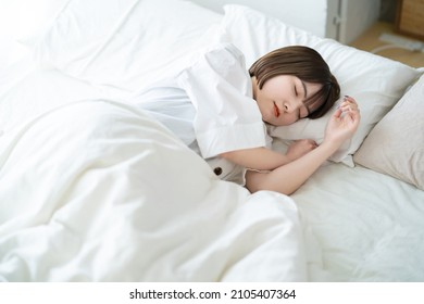 Female Sleeping On A Bed In A Bright Room