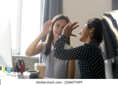 Female smiling colleagues celebrate business win, goal achievement at workplace, giving five, successful teamwork, businesswomen start work with new project, good brainstorm results, victory concept