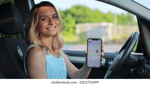 Female smiling and holding digital driving license. Beautiful woman successfully passed driving school test. Woman with driving license. Driver courses, exam and people concept. - Shutterstock ID 2351752499