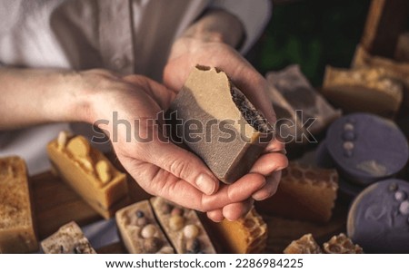 A female soap maker holds a handmade coffee soap in her hands. A lot of different sliced pieces. Eco-friendly natural craft cosmetics