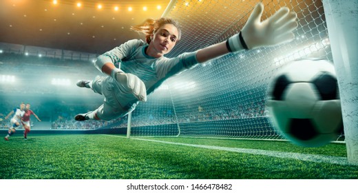 Female Soccer Goalkeeper catch the ball on a professional soccer stadium. Girls playing soccer - Powered by Shutterstock