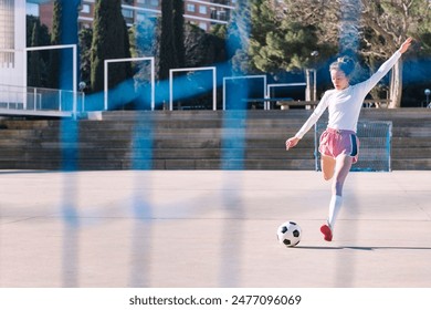 female soccer player kicking a ball into the goal - Powered by Shutterstock