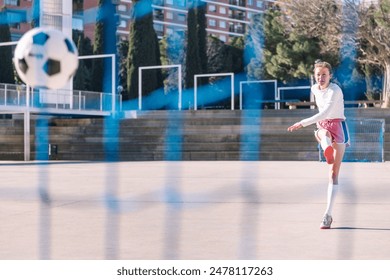 female soccer player kicking a ball into the goal - Powered by Shutterstock