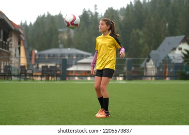 A female soccer player playing on the field teenage girl training with a football ball. - Powered by Shutterstock