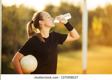 Female soccer player resting and drink water - Powered by Shutterstock