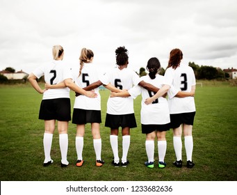 Female soccer players huddling and standing together - Powered by Shutterstock