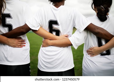 Female soccer players huddling and standing together - Powered by Shutterstock