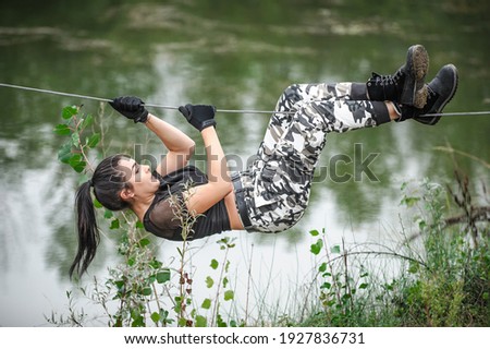Female soldier conducts the rope bridge water crossing exercise. Water survival training