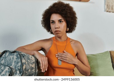 A female soldier reflects thoughtfully while preparing to leave for military service. - Powered by Shutterstock