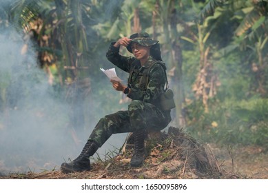 A Female Soldier Sitting In The Forest Reading A Letter