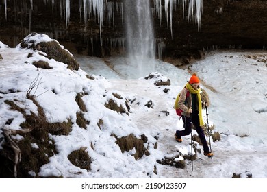 Female Solo Hiker Walking with Crampons and Walking Sticks on Frozen Ice in an Alpine Trial - Slovenia - Powered by Shutterstock