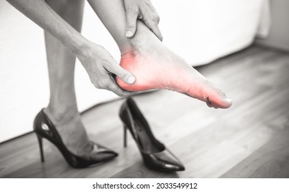 Female With Sore Feet Taking Off High Heels At Home