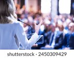 Female speaker at business conference, corporate presentation, workshop, coaching training, news conference, company meeting, public or political event. Public speaking concept.