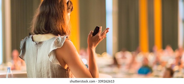 Female Speaker At Business Conference And Presentation. Audience At The Conference Hall. Business And Entrepreneurship. Business Woman. Horizontal Composition.