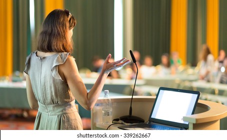 Female Speaker At Business Conference And Presentation. Audience At The Conference Hall. Business And Entrepreneurship. Business Woman. Horizontal Composition.