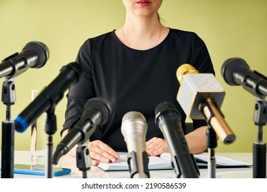 Female Speaker Holds Press Conference. Cropped Image Of Woman Sitting On Table With Set Of Different Microphones. Media Interview, Business And Entrepreneurship Event.